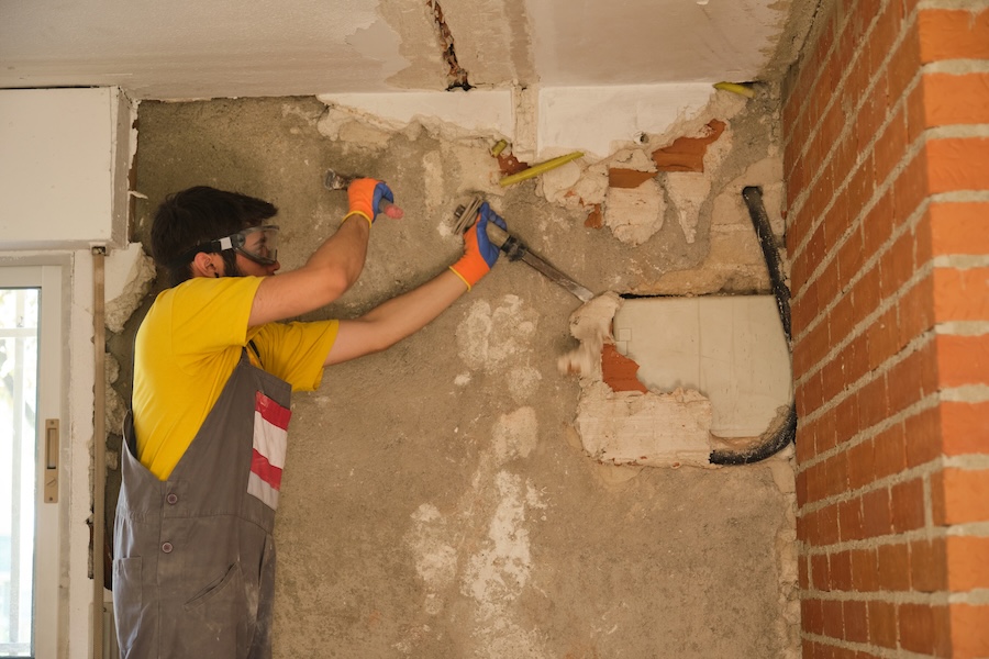 man works on wall renovation with hammer 2026 01 09 01 11 48 utc